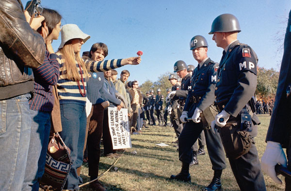 "A female demonstrator offers a flower to military police on guard at the Pentagon during an anti-Vietnam demonstration."