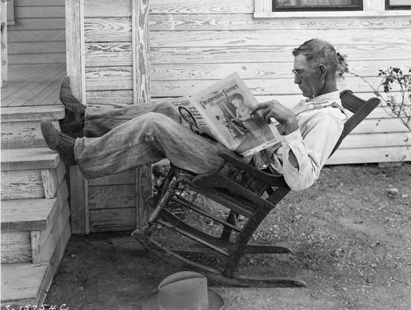 "Farmer reading his farm paper"