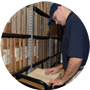 man opening a file folder in a file room