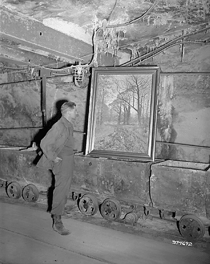 Corporal Donald Ornitz examines painting in underground 