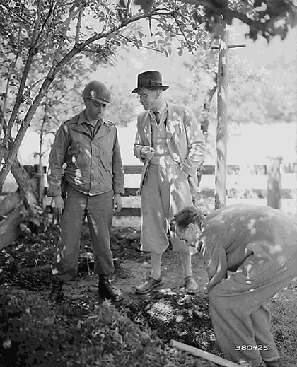SS Major Kurt Baron Haller Von Hallerstein admitted that he had buried nearly a million dollars worth of securities and jewelry near Garmisch, Germany.&nbsp; Hallerstein (center) watches with Tec 4 Frederick Wolinsky, New York, NY, as his brother Helmuth Baron Haller Von Hallerstein, digs. May 25, 1945&nbsp;