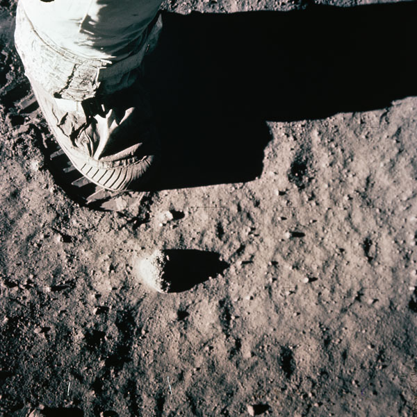 "Close-up view of an astronaut's leg and foot and footprint in the lunar soil..."