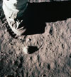 Close-up view of an astronaut's leg and foot and footprint in the lunar soil