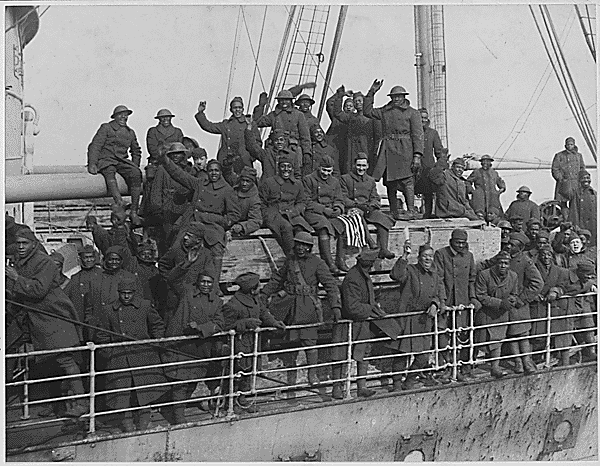 Members of the 369th Infantry Return Home; men waving from ship