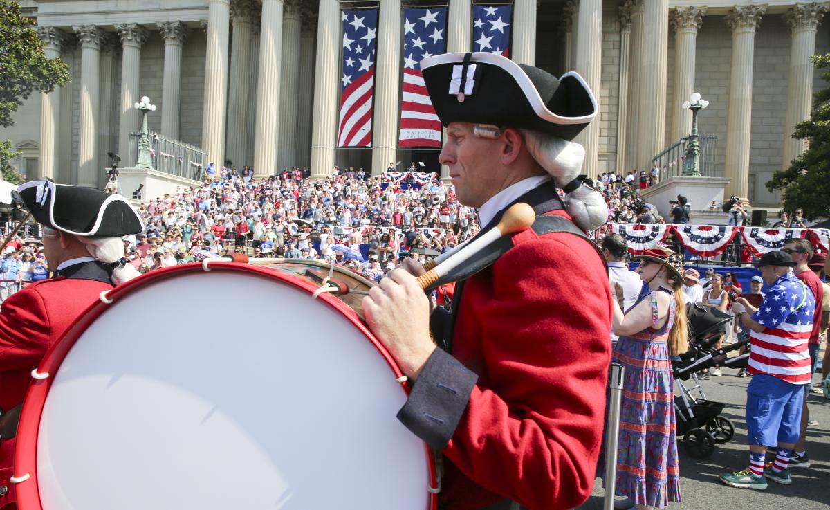 A drummer is seen walking in front of the National Archives Museum on the Fourth of July