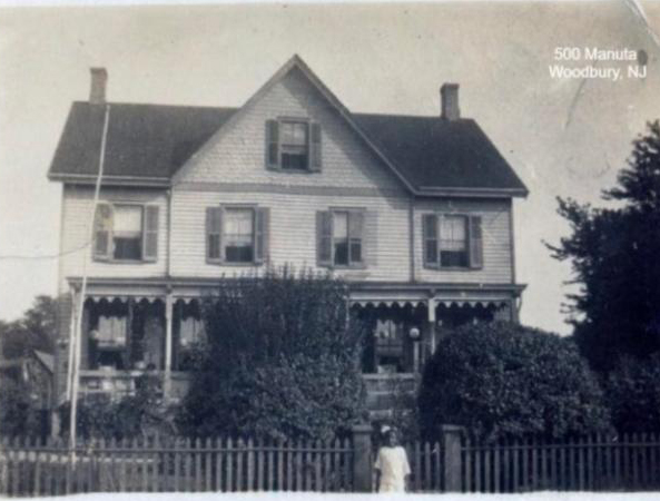 Large old house with a child standing in front