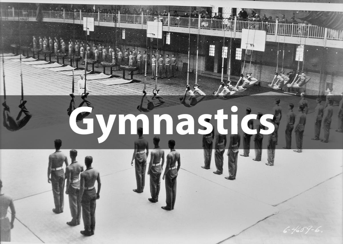 black and white photograph of men using gymnastics rings in a large gymnasium