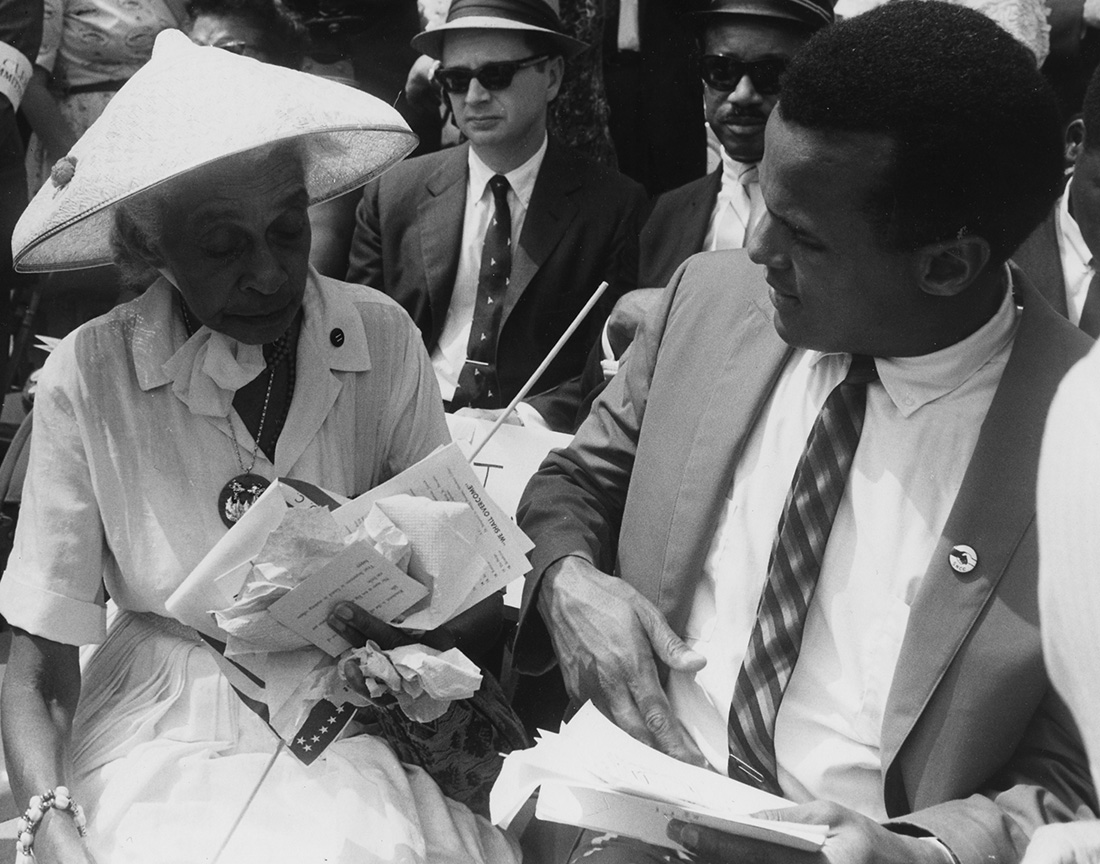 Harry Belafonte speaks with a woman at the 1963 March on Washington