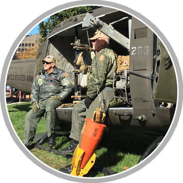 Members of the North Carolina Vietnam Helicopter Pilots Association sit on a Bell helicopter as they prepare for tours with the public during Members of the North Carolina Vietnam Helicopter Pilots Association sit on a Bell helicopter as they prepare for tours with the public during the grand opening weekend of the new Remembering Vietnam exhibit at the National Archives in Washington, D.C. (National Archives photo by Rania Hassan)