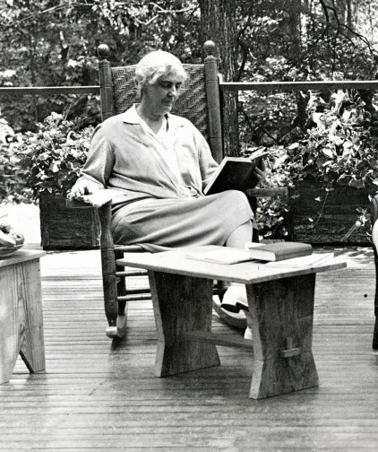 Lou Henry Hoover reads a book while seated on an outdoor deck