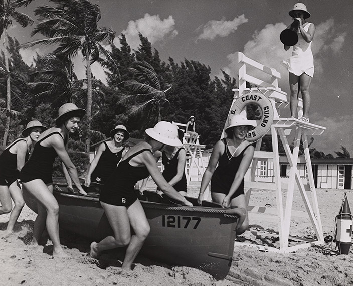 group of SPAR Surfmen pulling a boat over the sand