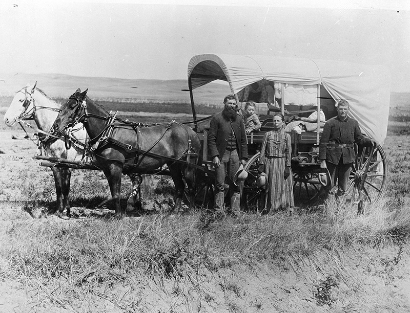 homesteading family in front of a wagon