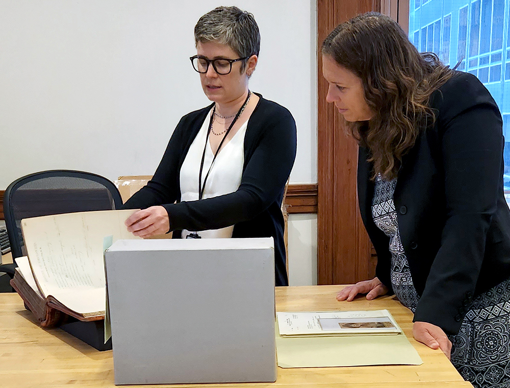 Kelly McAnnaney shows Colleen Shogan documents in National Archives at New York
