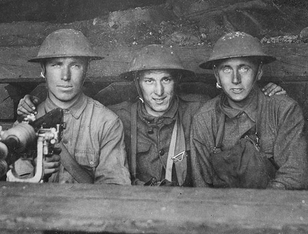 Three U.S. Army soldiers with a machine gun set up in railroad shop. June 1918