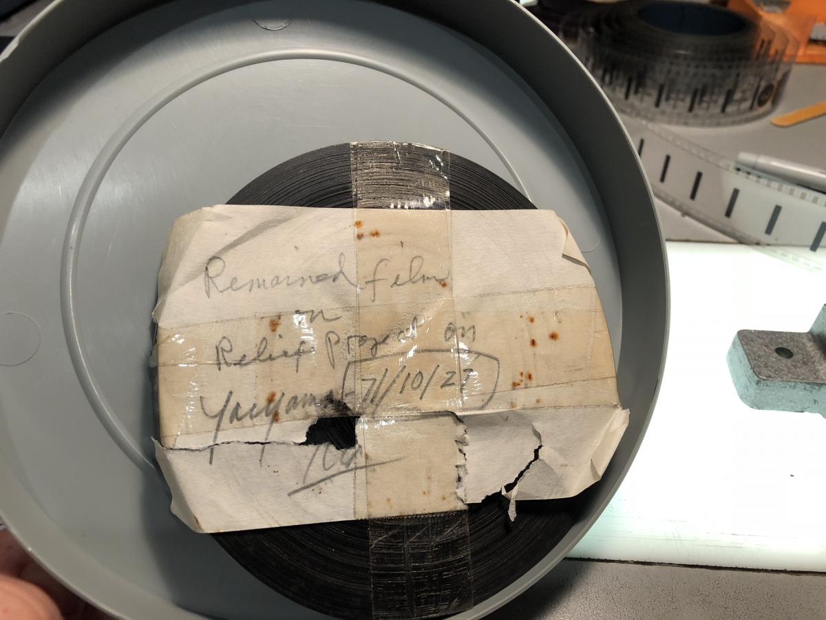 Film roll with paper taped to it identifying the subject as "Relief Project on Yaeyama".