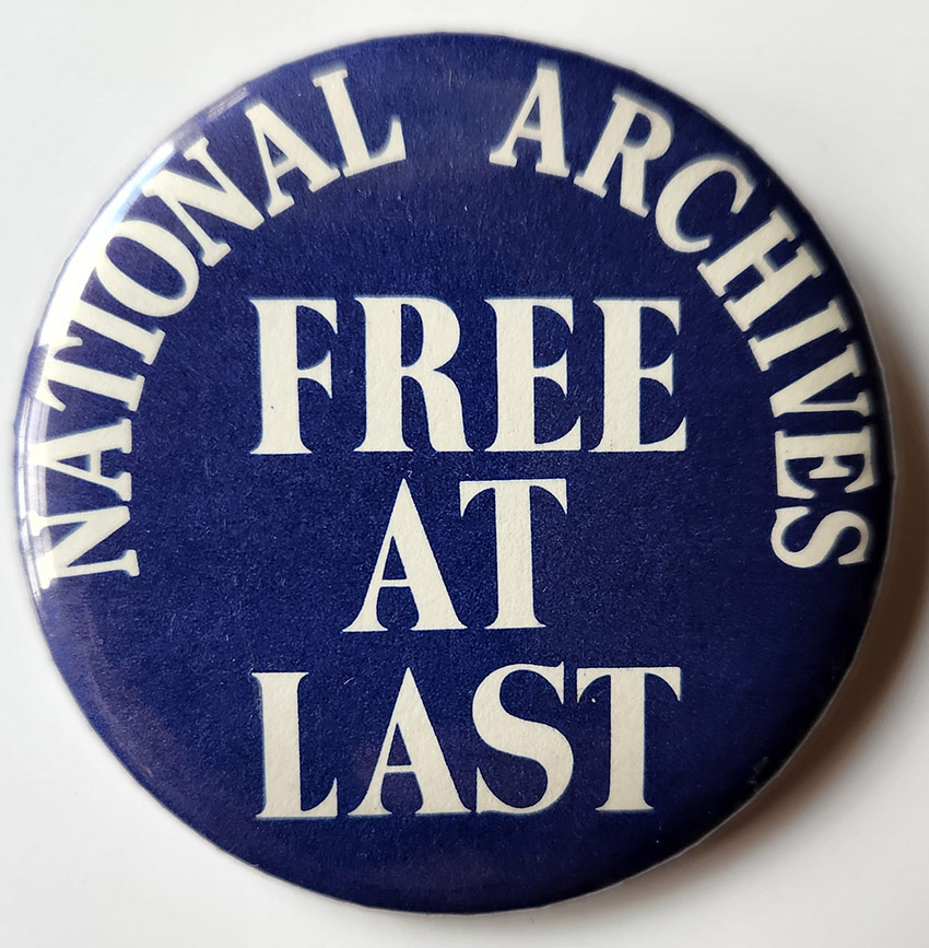 Dark blue button with white writing saying "National Archives: Free at Last"