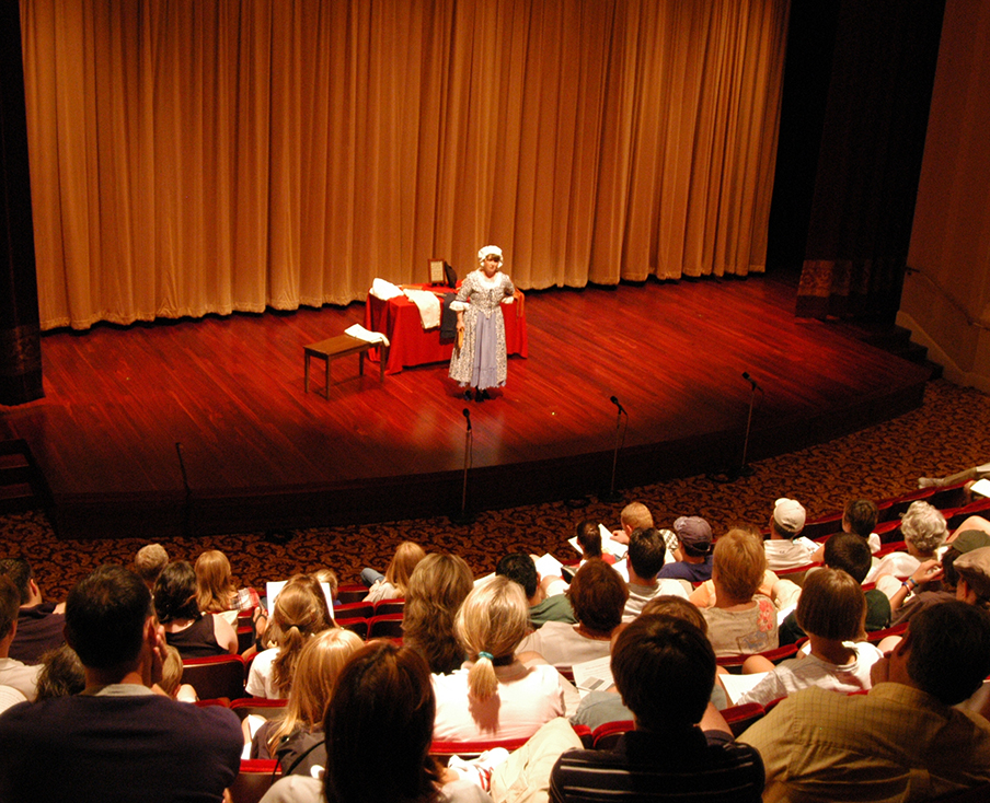 Woman in 18th-century clothing present a program in the McGowan Theater on July 4, 2005