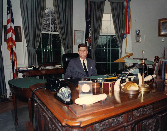 President John Kennedy at his desk in the Oval Office