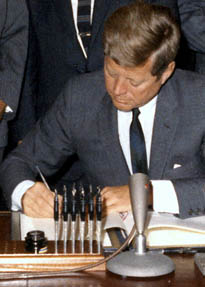 President Kennedy uses a pen from the pen holder recovered by the library. 