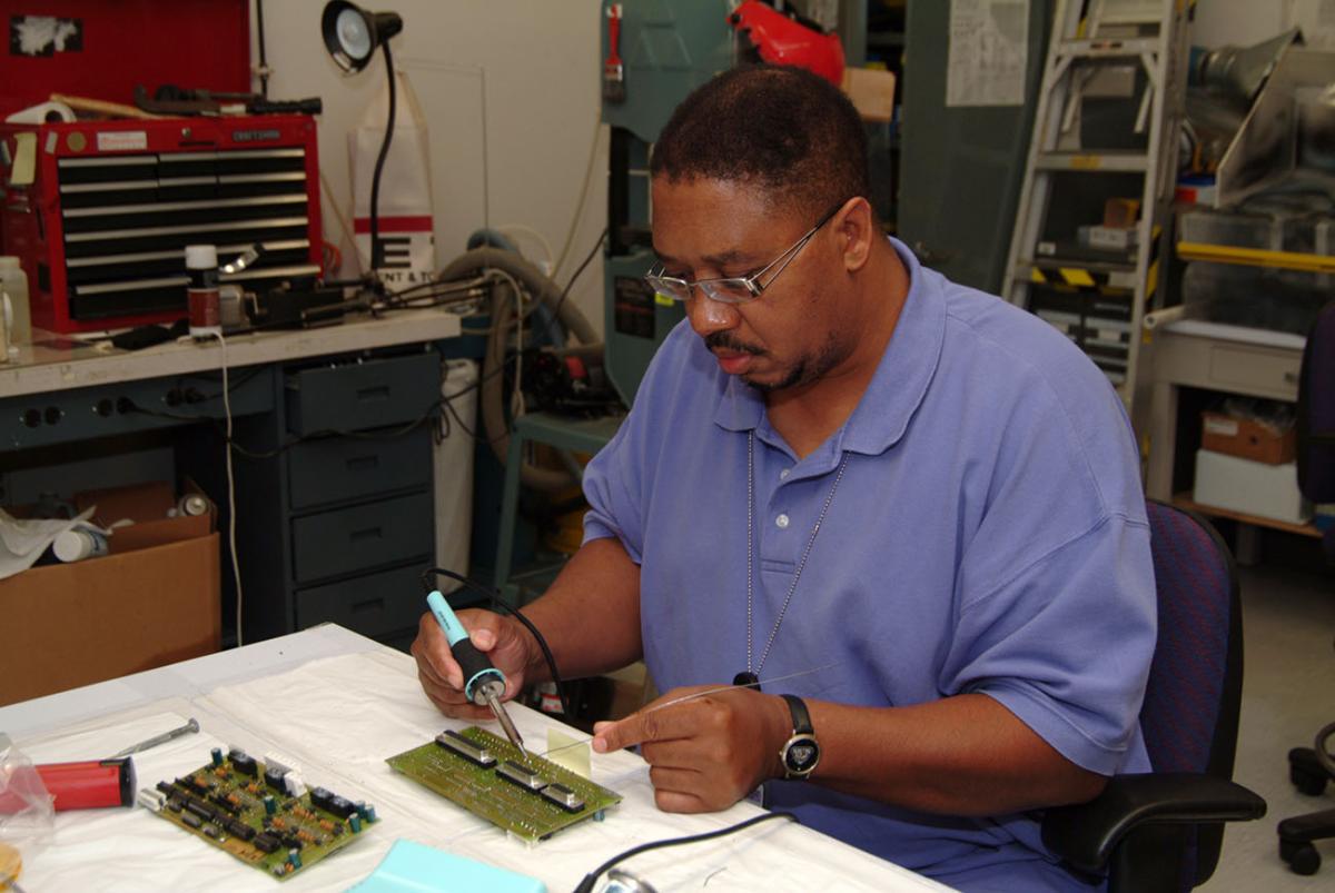 Electronics technician Kenneth Drummond repairs circuit boards
