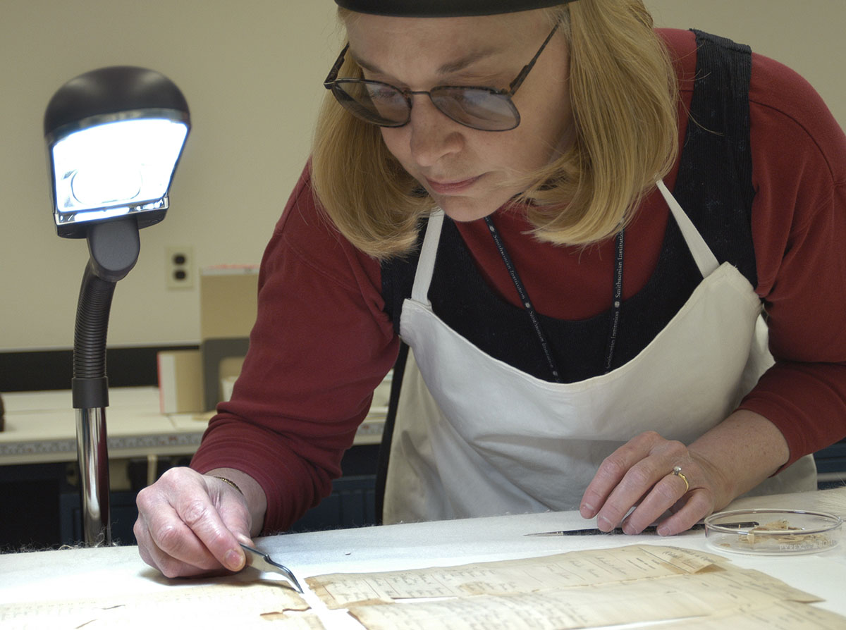 Conservator Lisa Isbell carries out conservation treatment on a paymaster s account sheet