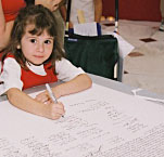 Young girl signing a facsimile of the Declaration of Independence