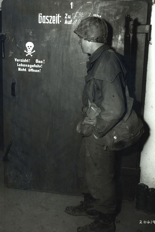 A U.S. soldier from the Seventh Army stands at the gas chamber door at Dachau