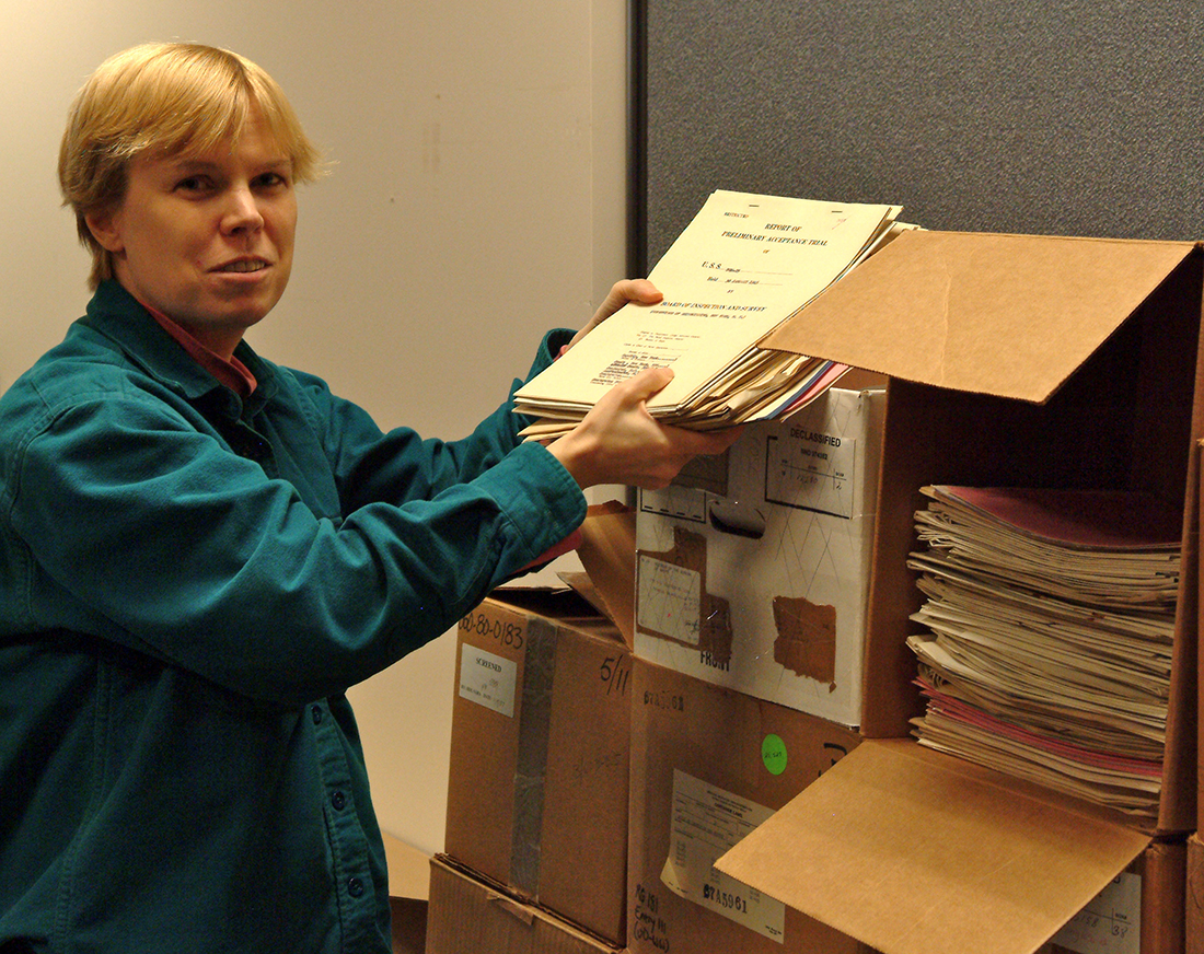 Diane Doerner looks through records from Record Group 38, Records of the Office of the Chief of Naval Operations. 