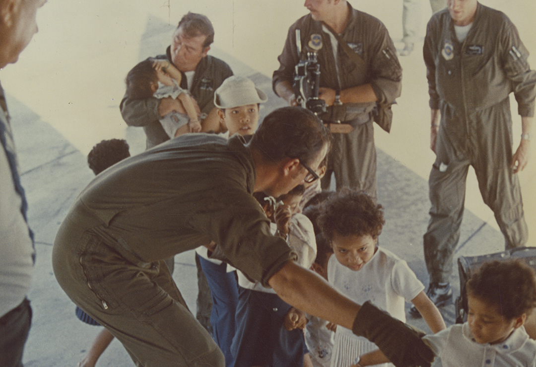 Flight crew members assist young Vietnamese children aboard C-141 prior to leaving for Clark AFB, Philippines, during Operation Babylift. April 1975.