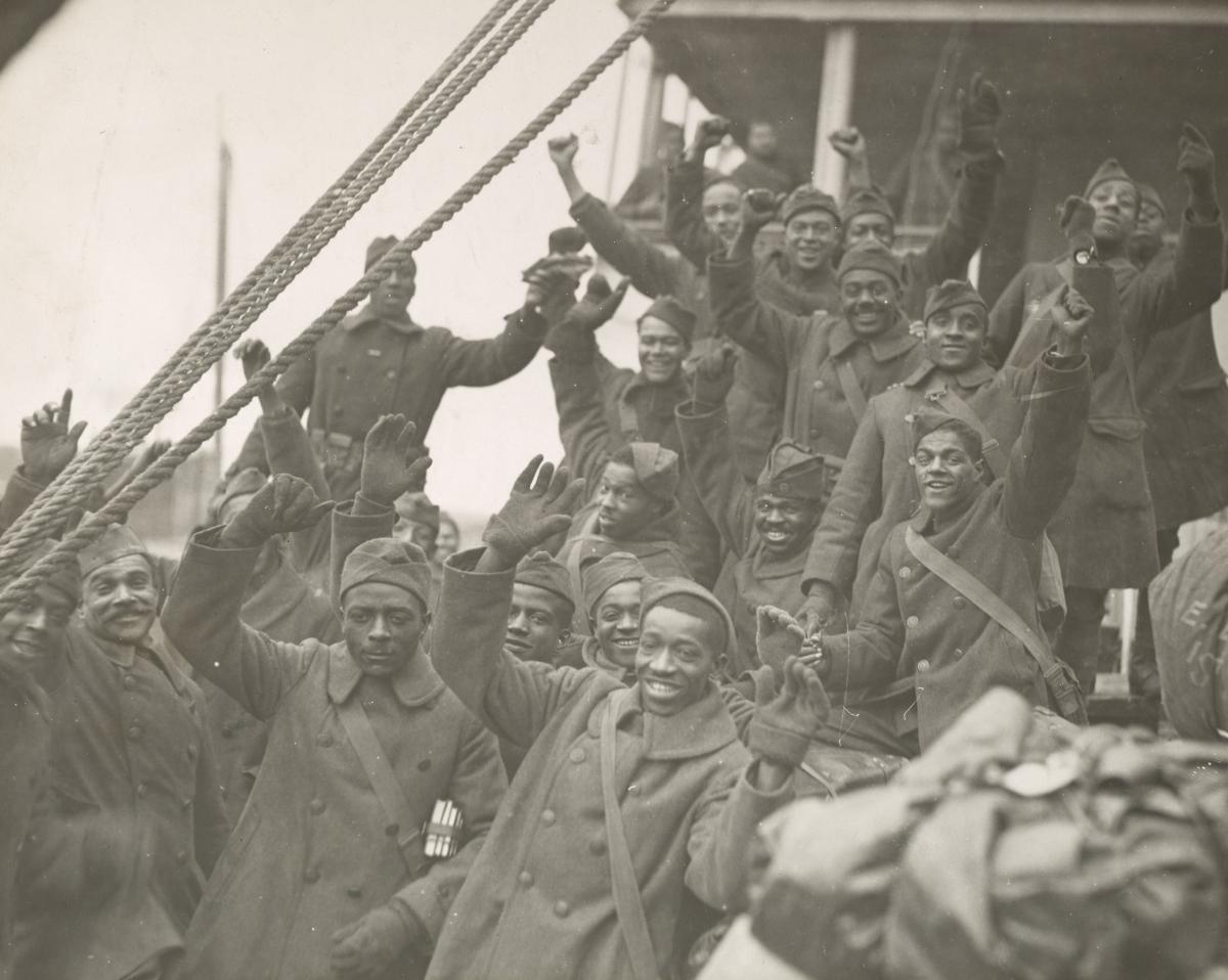 black soldiers on a ship with raised fists and waving