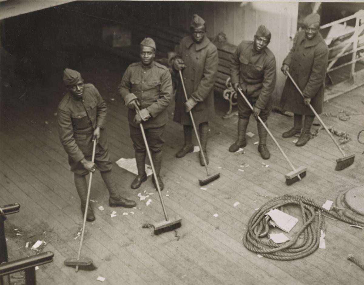 African American troops sweeping up kitchen deck on board the Celtic