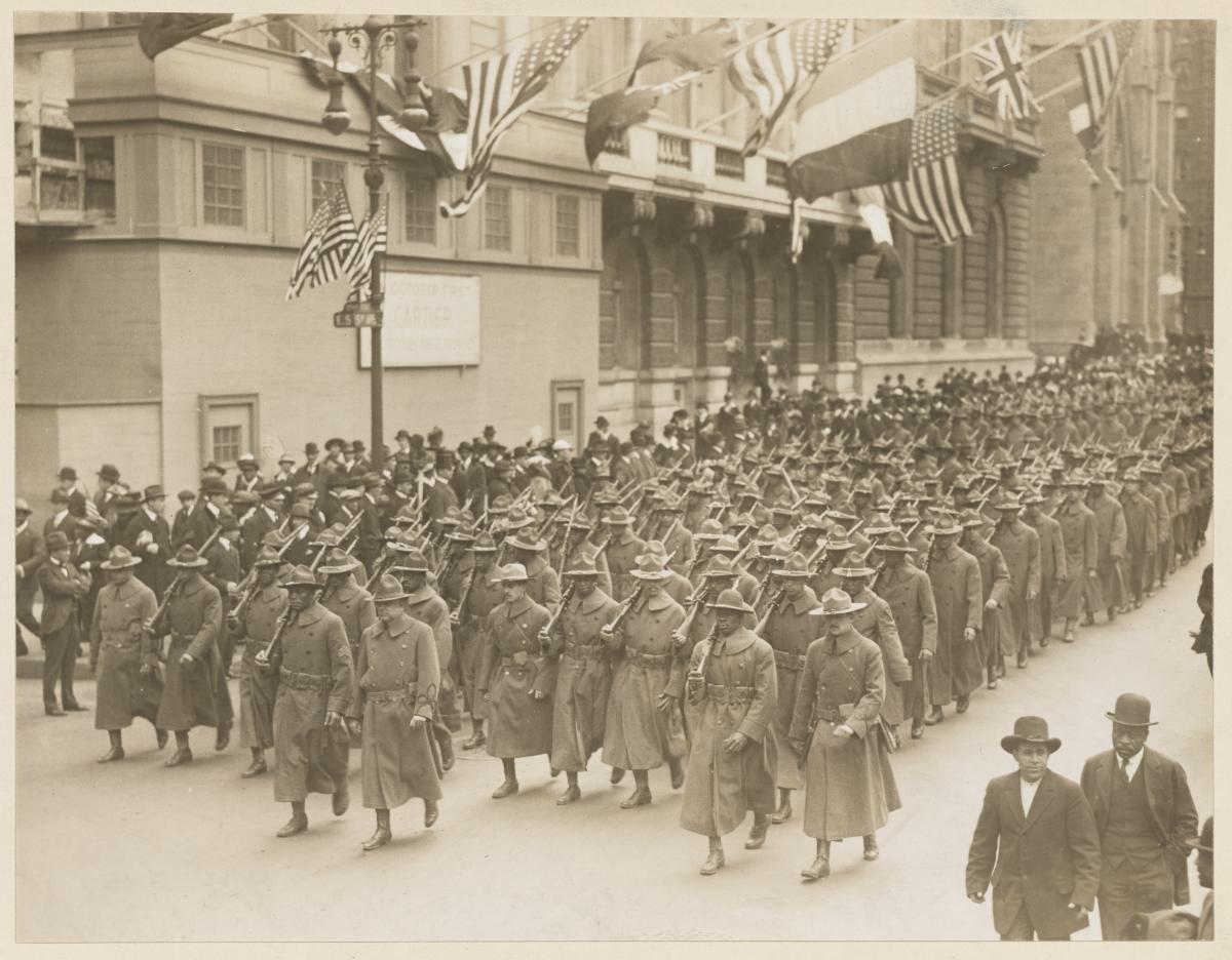 unit of soldiers in uniform with rifles over their shoulder marching in columns