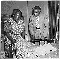 "Just one of the million mattresses made by low income-farm families - every mattress made by the family itself of surplus cotton. These are proud possessions in homes where such comfort was unknown before. This Maryland Negro woman shows her mattress to J. B. Pierce, a federal Negro field agent," ca. 1942. (FDR Presidential Library NLR-PHOCO-A-48223933(228))