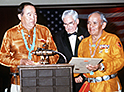 National Archives Identifier: 6439400, President of the Navajo Code Talkers, left, Joe Garza, ceremony chairman, center, and the vice-president of the Code Talkers present the commandant of the Marine Corps GEN. Alfred M. Gray Jr. with a copy of the Navajo Code Talkers Marine Corps hymn, 02/20/1988