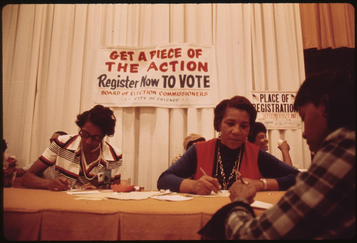 Women at a table register voters