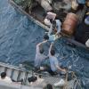 Crewmen of USS Durham take Vietnamese refugees from a small craft in the South China Sea