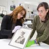 National Archives’ Supervisory Conservator Abigail Aldrich and Senior Conservator Lauren Varga examine a portrait of King Bhumibol Adulyadej of Thailand in a Silver Niello Frame with Gold Royal Cypher that was a gift from King Bhumibol Adulyadej to Presid