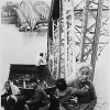 The old and the young flee Tet offensive fighting in Hue, managing to reach the south shore of the Perfume River despite this blown bridge.