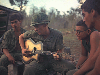 soldiers in vietnam relax with a guitar