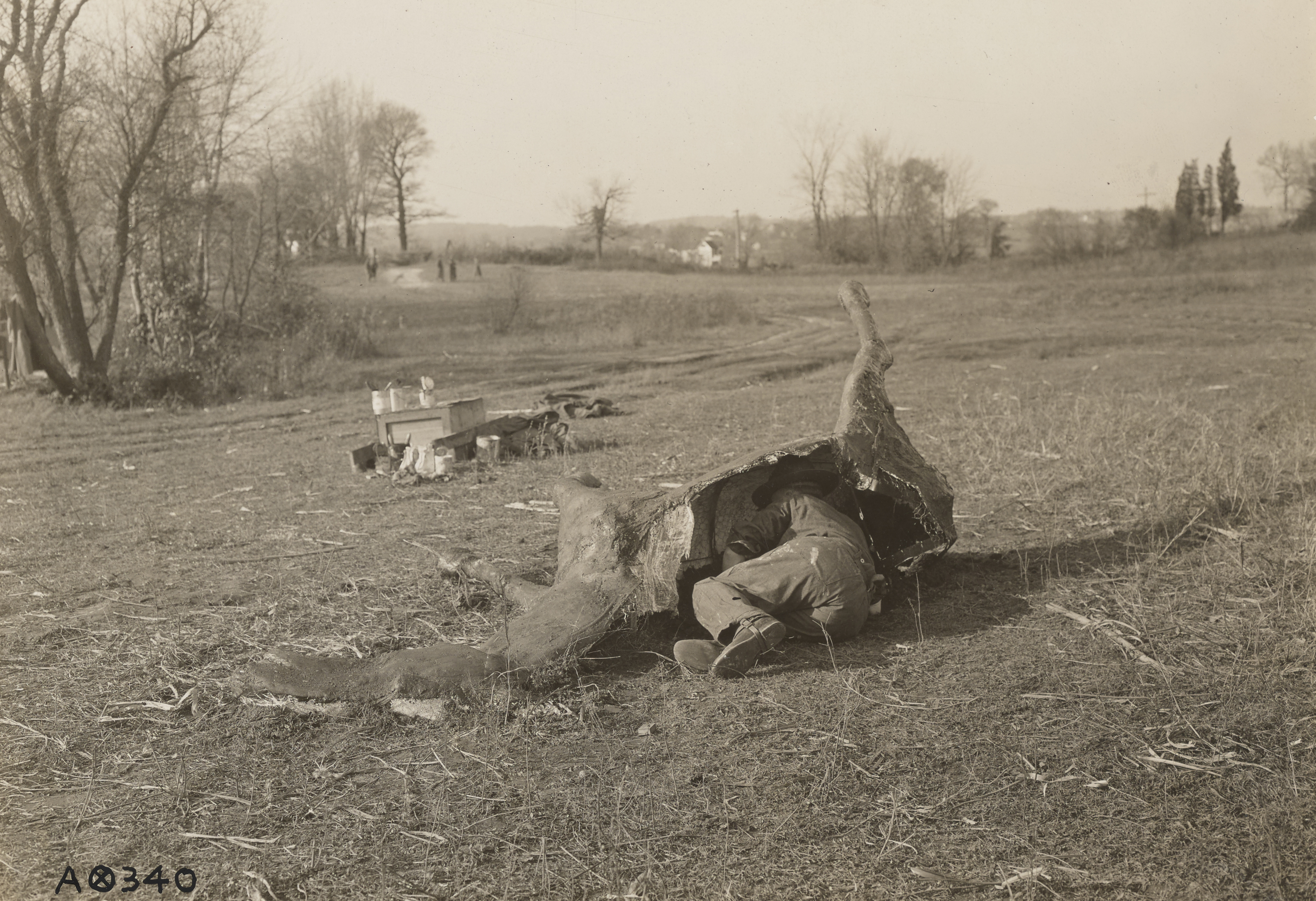 Soldier emerging from listening post camouflaged as carcass of horse