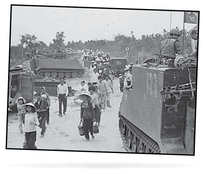 The old and the young flee Tet offensive fighting in Hue, managing to reach the south shore of the Perfume River despite this blown bridge.